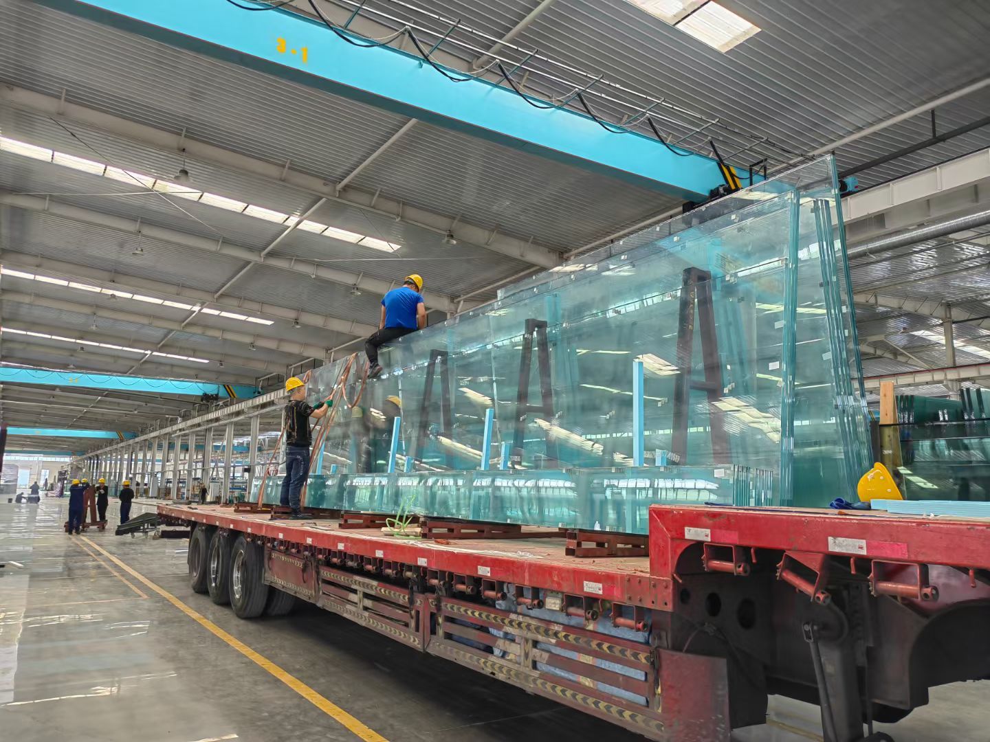 Large glass panels on transport racks during loading preparation.