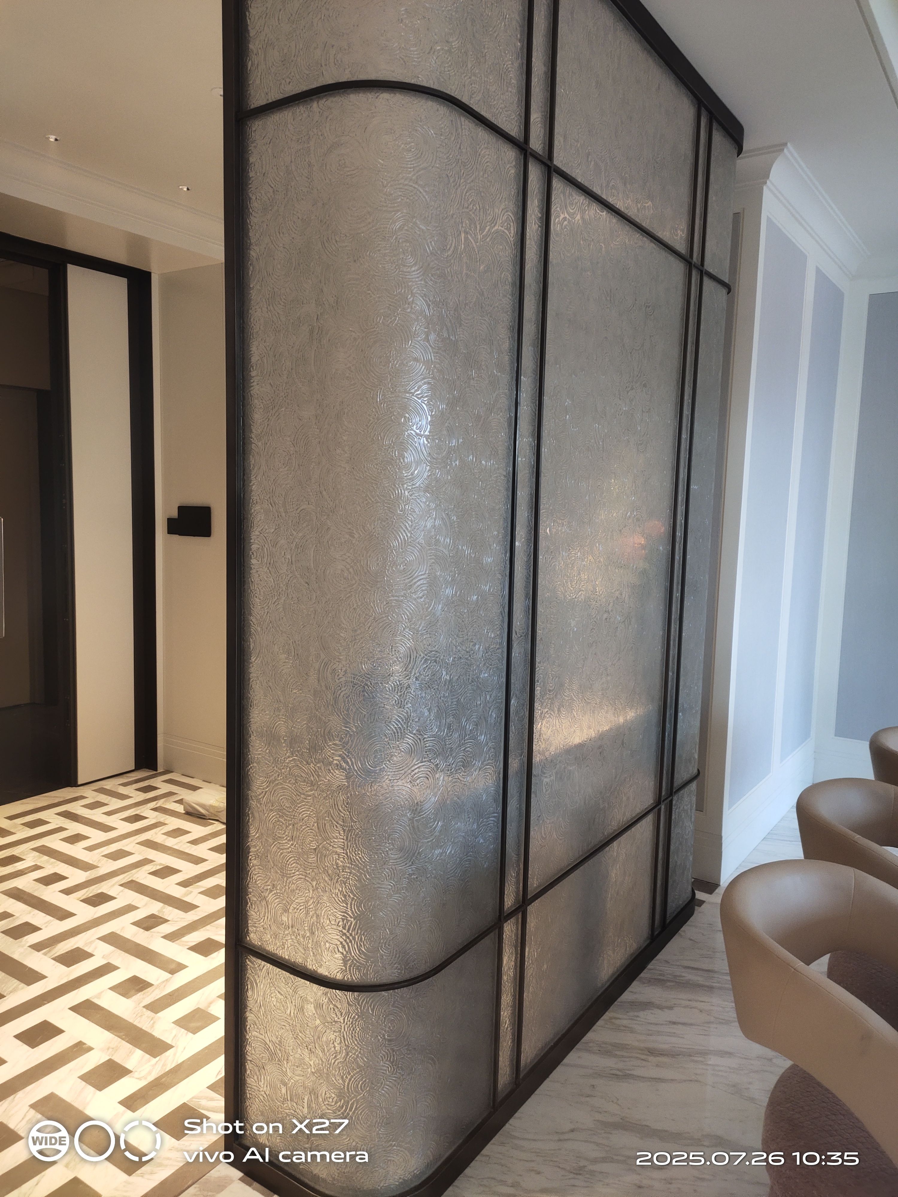 Textured artistic glass screen in a finished interior